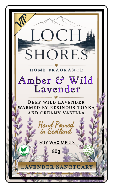 Front-facing product label for Loch Shores Home Fragrance 'Amber & Wild Lavender' soy wax melts, 80g. The label features a cream background with black and purple typography, a gold 'VIP' banner, a mountain and lake illustration, lavender sprigs along the bottom, and a thin black border.