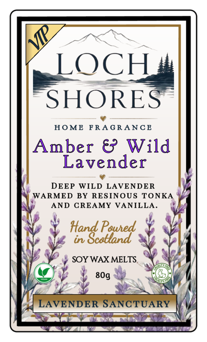 Front-facing product label for Loch Shores Home Fragrance 'Amber & Wild Lavender' soy wax melts, 80g. The label features a cream background with black and purple typography, a gold 'VIP' banner, a mountain and lake illustration, lavender sprigs along the bottom, and a thin black border.